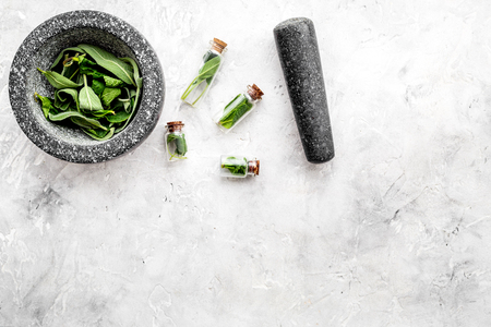 Phytotherapy. Herbs in mortar bowl and in small glasses on grey background top view.の写真素材