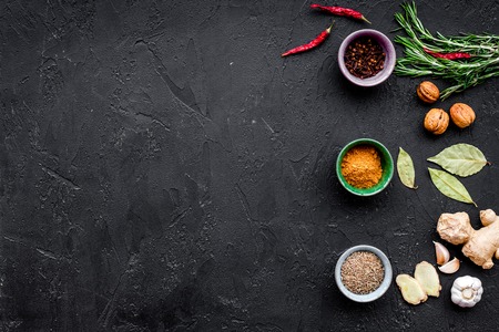 Gastronomy, culinary. Secrets of tasty dishes. Seasoning and spices. Rosemary, ginger, chili pepper on black background top viewの写真素材