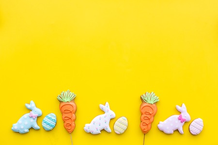 Easter gingerbread and cookies. Easter eggs and Easter bunny concept. Yellow background top view.