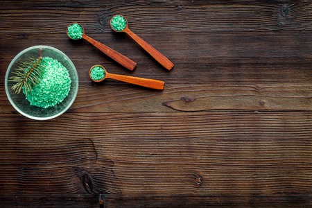 Spa cosmetics. Green spa salt with pine scent on dark wooden background top view.の写真素材