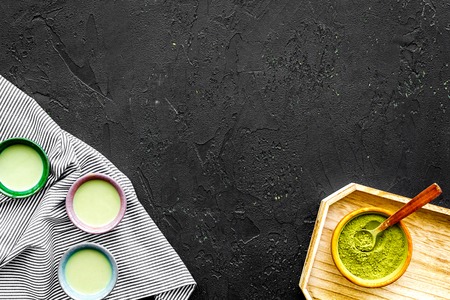Japanise tea ceremony with matcha tea. Bowl with powder and cups with beverage on tablecloth black background top view copy spaceの写真素材