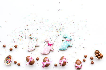 Celebrate Easter. Modern signs of Easter. Chocolate Easter eggs and Easter bunny cookies. White background top view.の写真素材