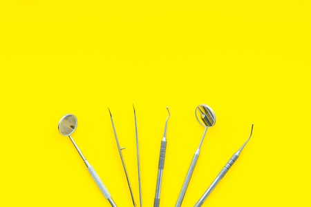 Dentist tools. Teethcare, dental health concept. Yellow background top view copy space