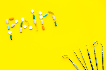 Metal dentist tools. Yellow background top view.の写真素材