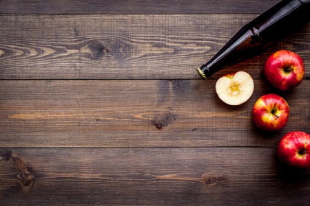 Apple cider. Low-alcoholic beveradge in dark bottle on dark wooden background top view.の写真素材
