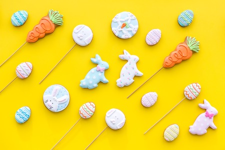 Easter background. Cookies in shape of Easter eggs and Easter bunny. Yellow background top view.の写真素材
