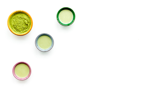 Brew matcha tea. Bowl with powder and cups with beverage on white background top view.の写真素材