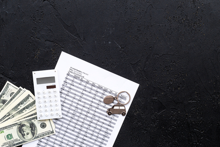 Car credit concept. Money and calculator near keychain in shape of car silhouette on black background top view copy spaceの写真素材
