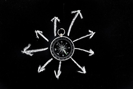 Direction of movement, travel direction. Compass among the arrows on black background top view copy spaceの写真素材