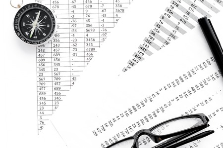 Business development concept. Direction. Compass near documents, glasses, pen on light background top viewの写真素材