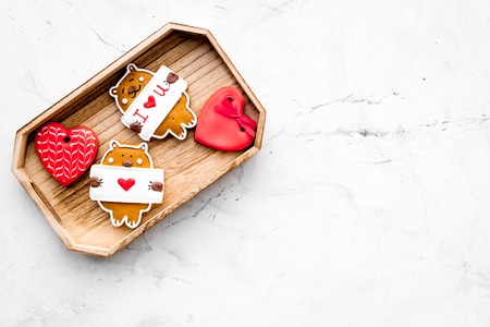 Sweet gift for St Valentines Day. Heart shaped gingerbread in tray on light grey background top view...