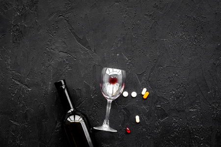 Alocohol abuse and alcoholism treatment concept. Glasses, bottles and medcine pills on black background top view copy spaceの写真素材