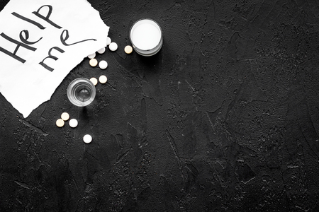 Treat alcohol dependence. Words Help me near pills on black background top view copy spaceの写真素材
