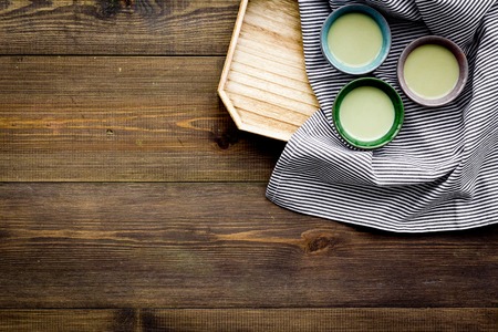 Make matcha tea. Matcha tea in small cups ready to drink on dark wooden background top view copy spaceの写真素材