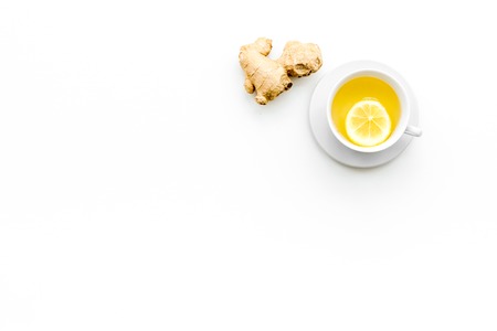 Cup of ginger tea near ginger root on white background top view.の写真素材