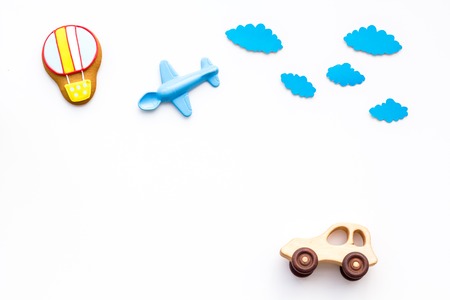 Travelling with child concept. Car and airplan toy, air balloon cookie on white background top view copy spaceの写真素材