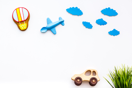 Travelling with child concept. Car and airplan toy, air balloon cookie on white background top view.の写真素材