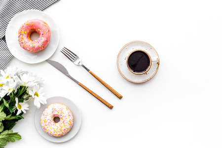 Romantic breakfast with flowers on the table. Coffee with dessert on white background top view.の写真素材