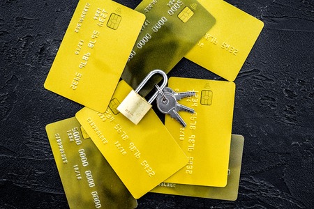 Electronic payments protection. Bank cards near lock and keys on black background top view.の写真素材