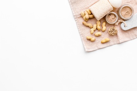 Natural cosmetics for skin care. Body scrub with peanut. White background top view copy spaceの写真素材