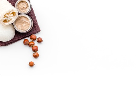 Natural cosmetics for skin care. Body scrub with hazelnut. White background top view copy spaceの写真素材