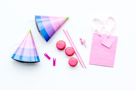 Birthday party accessories. Party hat, sweets, paper bag for gift on white background top view copy spaceの写真素材