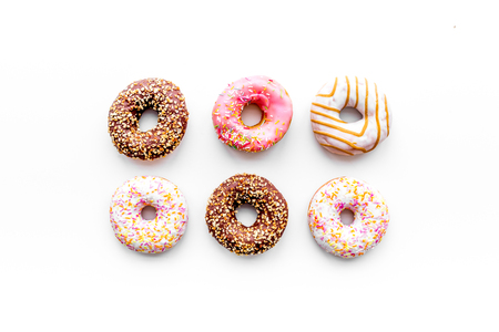 Donuts decorated icing and sprinkles on white background top view copy space patternの写真素材