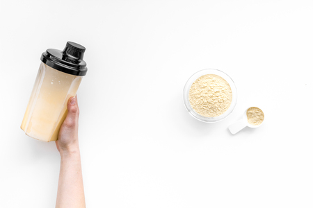 Sports nutrition. Scoop of protein near shaker on white background top view copy spaceの写真素材