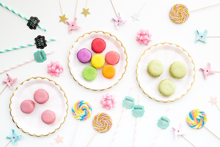 Sweets for party background. Macarons and lollipop on white top viewの写真素材
