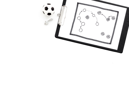 Sport coach concept. Pad with tactic plan of the match near whistle and football ball on white background top view copy spaceの写真素材