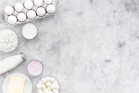 Natural farm products. Milk, cottage, eggs on grey background top view.