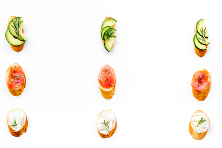 Homemade sandwiches with french baguette, salmon, cheese and vegetable on white kitchen table background top view mock-upの写真素材