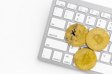 Bitcoin with keyboard on white table background top view space for textの写真素材