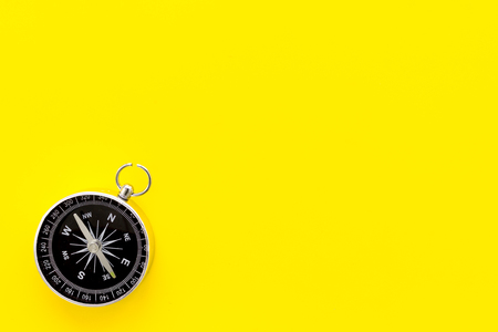 Direction concept with compass on yellow background top view mockupの写真素材
