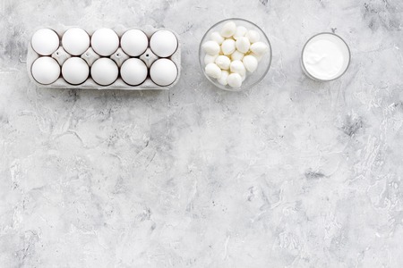 Fresh dairy products and eggs s on grey table top view copy space