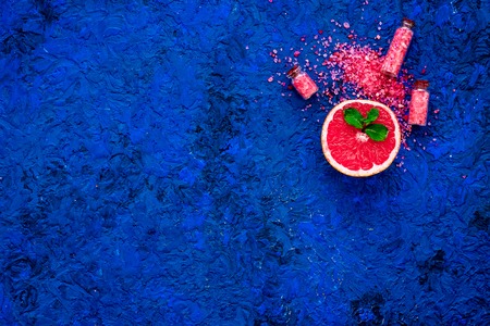 Organic cosmetic with grapefruit for homemade spa with salt and fresh fruit on blue background top view mock-upの写真素材