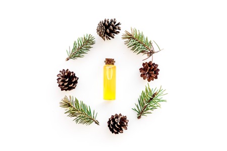 Pine essential oil in bottles on white background top view copy space. Pattern with pine branch and coneの写真素材