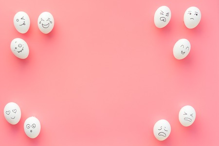 Emotions in communication at social media. Faces drawn on eggs. Happy, smile, sad, angry, in love, saticfied, laughing. Pink background top view copy spaceの写真素材