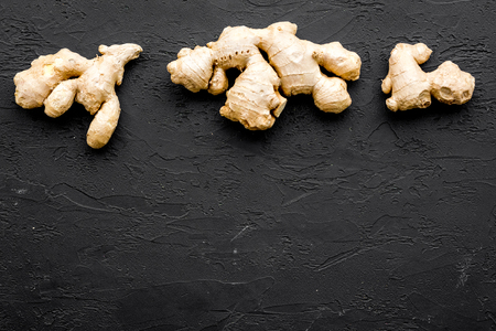 Whole ginger roots on black background top view space for textの写真素材