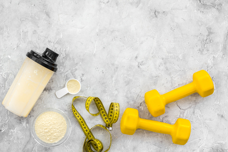 Sport diet protein nutrition and fitness equipment on gray stone background top view mock up.の写真素材
