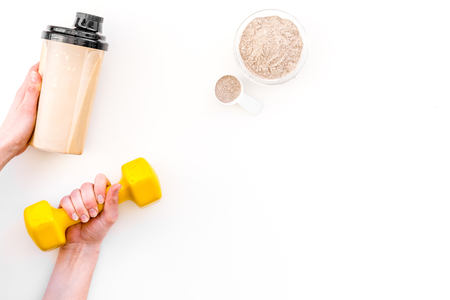 Protein powder for fitness nutrition to start training and bars on white desk background top view mock-upの写真素材