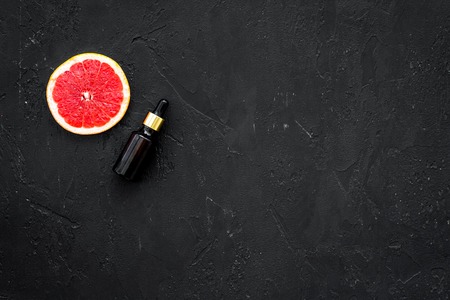 Organic cosmetic with grapefruit for homemade spa with oil and fresh fruit on black table background top view mock-upの写真素材