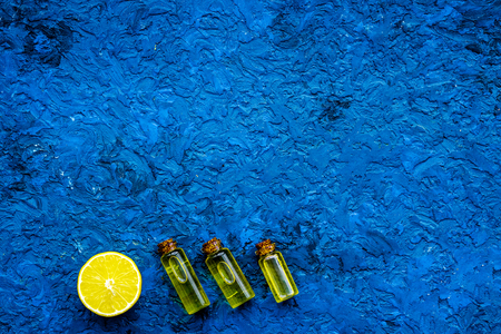 Natural cosmetics set with fresh lemon and organic oil on blue table background top view mock up.の写真素材