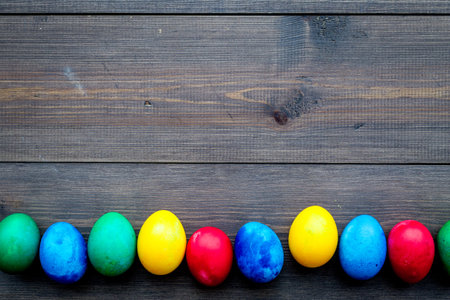 Easter celebration with colorful eggs. Wooden desk background top view mock up