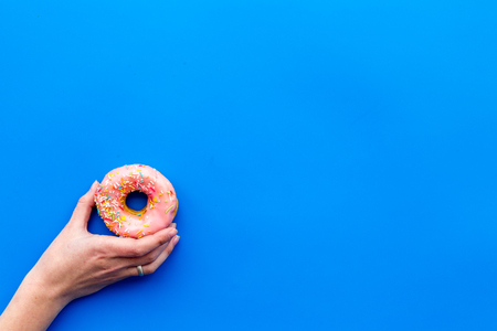 Sweet tasty snack. Glazed donut on blue table background top view copy spaceの写真素材