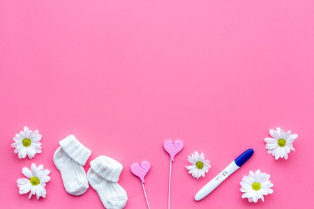 Waiting for a baby with positive pregnancy test and flowers on pink background top view mockupの写真素材