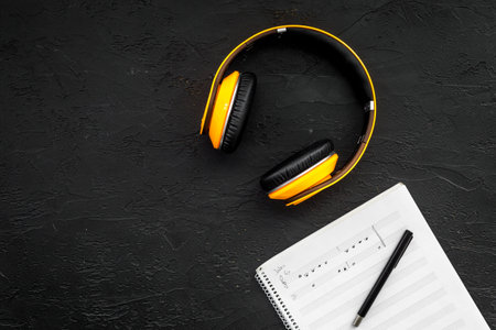 Composer office desk . Workplace of musician with headphones and notes black background top view mockup.の写真素材