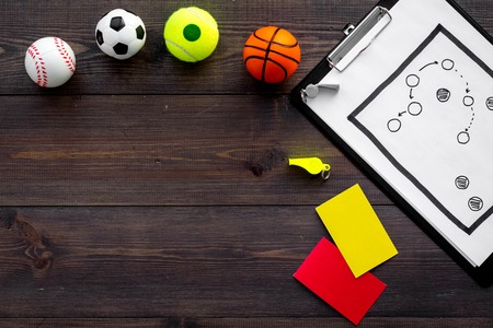 Sport judging concept. Soccer referee. Tactic plan for game, football ball, red and yellow cards, whistle on wooden background top view copy spaceの写真素材