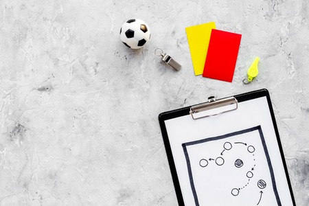 Sport judging concept. Soccer referee. Tactic plan for game, football ball, red and yellow cards, whistle on stone background top view,の写真素材