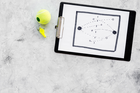 Sport coach concept. Pad with tactic plan of the match near whistle on stone background top view.の写真素材